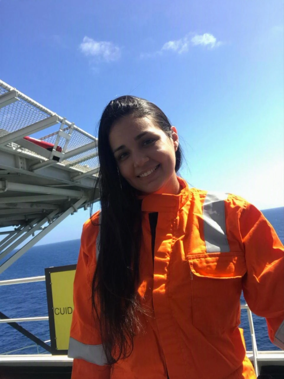Retrato da autora do JSST, com uniforme de segurança laranja em ambiente offshore